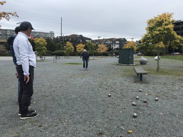 Pétanque players throwing boules in a park